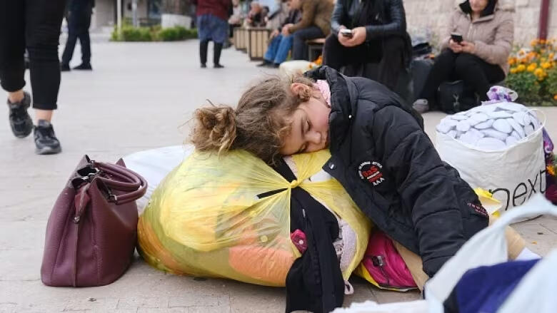 Armenian girl in Stepanakert sleeps on top of bags of belongings as her family prepares to flee her ancestral home of Artsakh (Nagorno-Karabakh)